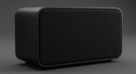 Obraz premium Black wireless speaker with fabric grille on dark background modern audio equipment for home or office use