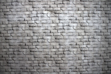 Obraz premium Neutral gray brick wall texture with subtle shadows and worn stone details, ideal for backgrounds, architecture projects, design mockups, urban scenes, or grunge-themed compositions and overlays.