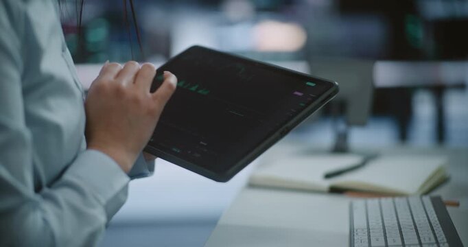 Close Up of Professional Hands Using Tablet to Monitor Stock Market Trends and Green Candlestick Charts. Concept of Mobile Trading, Digital Asset Management, and Real Time Financial Data Tracking.