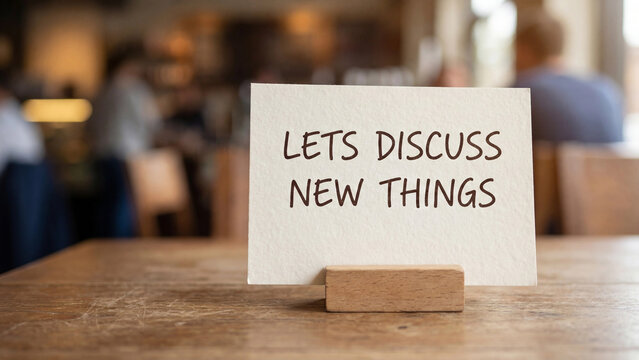 Lets discuss new things conversation invitation card on cafe table for open dialogue idea sharing brainstorming innovation meeting and collaborative communication in business settings