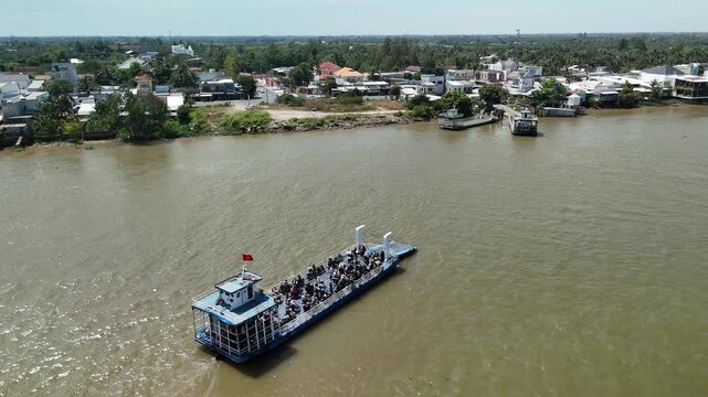 Cao Lanh City, Dong Thap, Southwest Vietnam &ndash; 4K aerial drone footage of ferry boats crossing the Mekong River with riverside houses and rural delta landscape