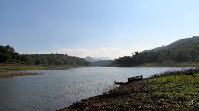 The serene and beautiful landscape with the Periyar River at Ayyappankovil in Idukki, Kerala, India | Wooden boats are parked on the riverbank