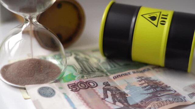 Russian money and an oil barrel with an hourglass