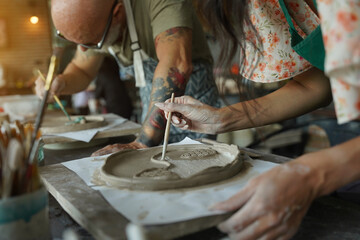A happy couple makes ceramic plates in a workshop