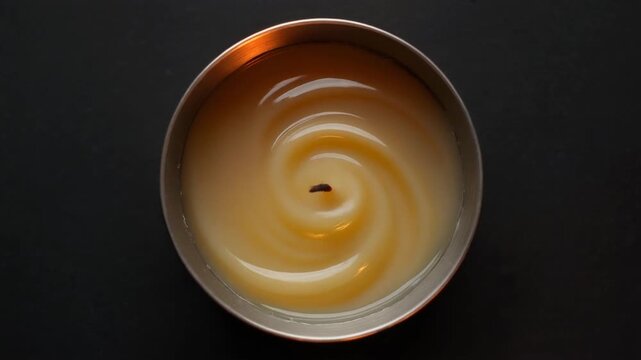 Top view of unlit candle with melted wax in spiral pattern