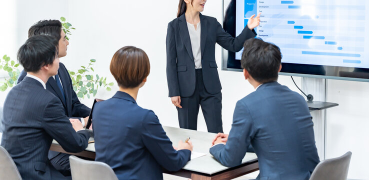 プレゼンするスーツを着た女性