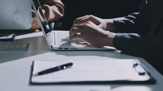 Accountant reviewing printed financial reports at messy office desk with calculator and sticky notes under soft window daylight for audit and corporate finance work