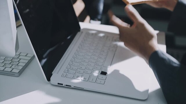 Accountant reviewing printed financial reports at messy office desk with calculator and sticky notes under soft window daylight for audit and corporate finance work