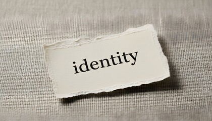 A torn paper fragment displaying the word identity set on a textured background, exploring self-awareness concept