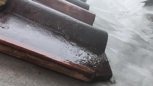 Rainwater Flowing Over Wet Saturated Clay Roof Tiles
