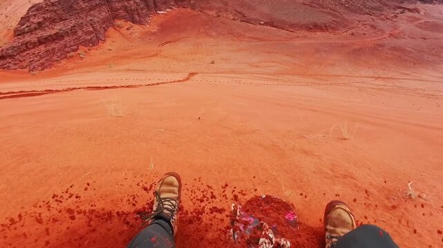 POV rider learning solo sandboarding sports sit on board go downhill on steep red dune in Wadi rum with struggle balance challenge and failed attempts adventure concept Jordan. Practise makes perfect