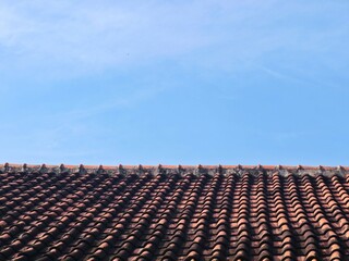 Fototapeta premium Traditional mediterranean terracotta roof tiles under a clear blue sky. Perfect for construction, real estate, or travel-themed projects