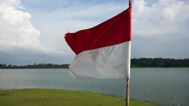 The single large red and white Indonesian flag flutters in the strong wind ahead of the 81th Independence Day of the Republic of Indonesia.