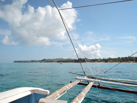 Tropical paradise with crystal clear water and traditional boats on the shore of Boracay Island, Philippines.