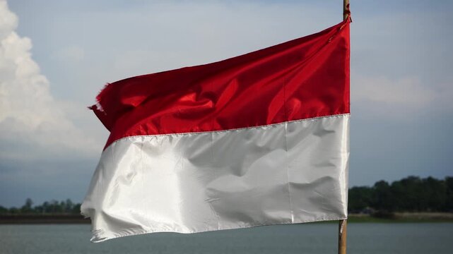 The single large red and white Indonesian flag flutters in the strong wind ahead of the 81th Independence Day of the Republic of Indonesia.