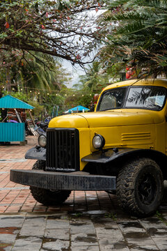 Vintage Yellow Truck Parked in a Tropical Outdoor Setting