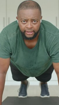 Man in tee starting low push-up performing reps with animated counter above watch tracking fitness