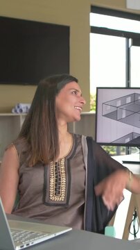 Vertical video: Looking woman in kurta in studio glancing from 3D screen to window on cue, laptop