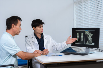 Obraz premium Male doctor specialists in treatment the process of osteoarthritis and knee arthroplasty after x-ray, doctors explaining symptoms and treatment to patients.