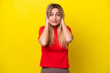 Fototapeta premium Young Uruguayan woman isolated on yellow background frustrated and covering ears