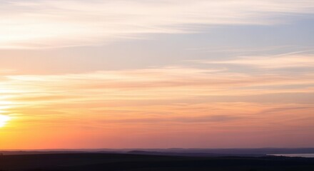 Obraz premium Scenic Sunset Over a Calm Horizon with Soft Clouds and Warm Colors