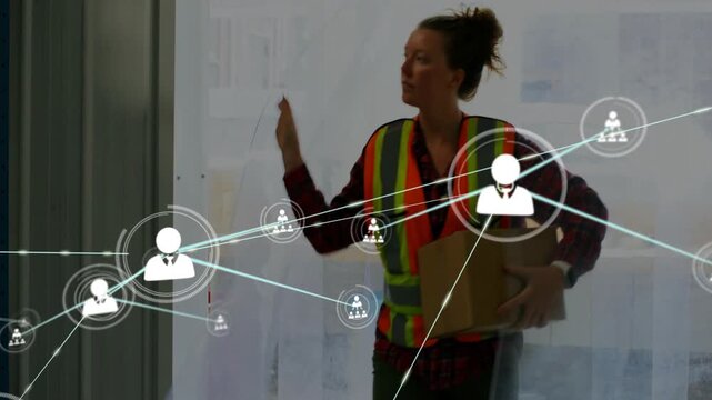 Woman warehouse worker entering holding box while overlay growing over her and racks tracking stock