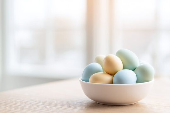 Minimalist Easter Still Life with Pastel Colored Eggs in White Ceramic Bowl on Light Wood Table