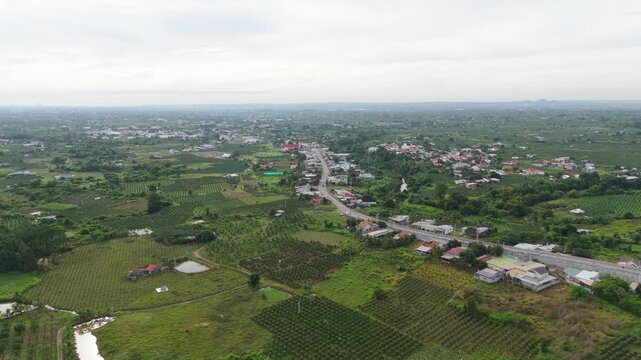 Aerial drone view of countryside town surrounded by green farmland and rural landscape