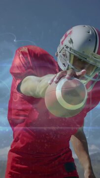 Vertical video: Football player coming to lens, passing for practice with blue streak tracing ball