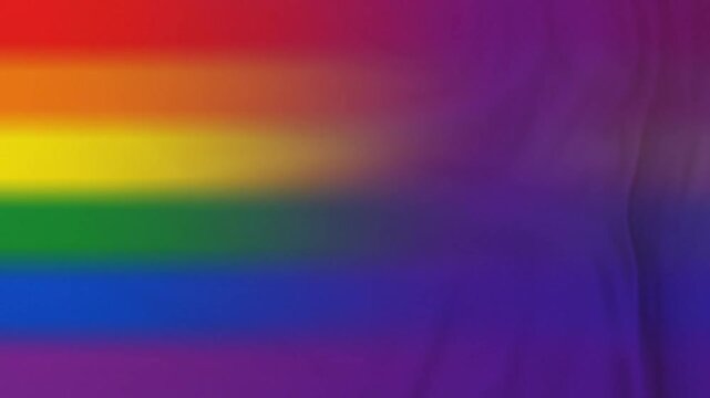 Abstract, flowing fabric with vibrant rainbow gradient representing diversity and inclusion