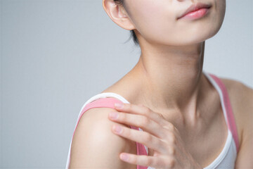 Woman touching her shoulder and neck with hand