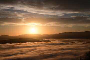 Obraz premium stunning sunrise between the fog and clouds in the coastal mountains