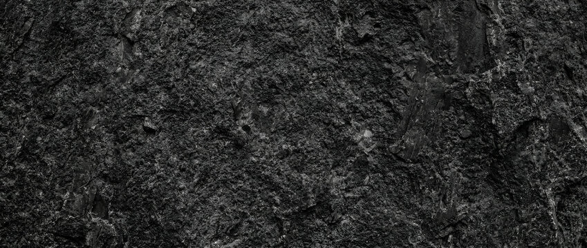 Exploring a rugged dark rock texture on a natural surface through a closeup macro view
