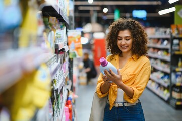 Obraz premium Woman shopping for product in supermarket aisle