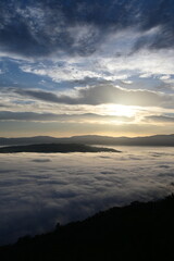 Fototapeta premium cloudy sunrise above the fog and below the clouds