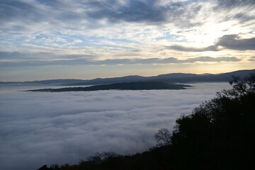 Fototapeta premium cloudy sunrise above the fog and below the clouds