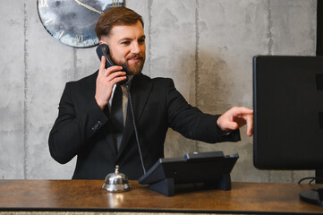 Hotel concierge talking on phone helping client