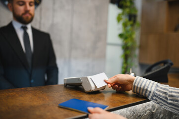 Fototapeta premium Person making a contactless payment at hotel reception