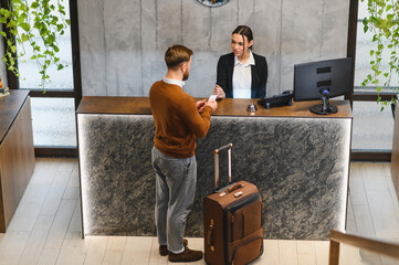Traveler checking in at modern hotel reception desk © Serhii