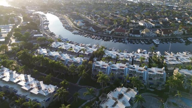 Marina front cluster overlooking Seabridge Park and Huntington Harbor channel network near Edinger Ave. Bright rooftops, long shadows, reflective water warm coastal tones in Huntington Beach, CA