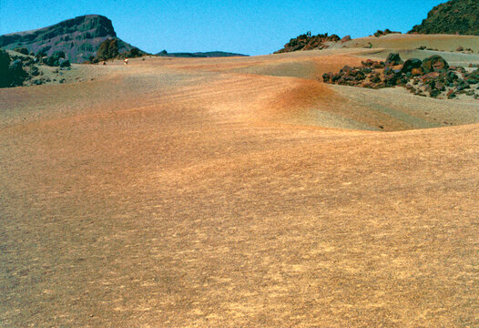 Tenerife, Canary Islands, Spain, July 20, 1999. Landscape of Teide National Park, a popular tourist destination, consisting of a large expanse of yellowish-red volcanic sand with dark volcanic rocks