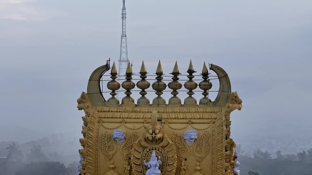 Cinematic drone view of golden kalasa atop Sri Chamundeshwari Temple gopuram, Chamundi Hills,Mysore