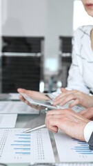 Fototapeta premium Business person's hands holding a pen, reviewing and signing a legal contract or agreement document during an important office meeting, finalizing a deal
