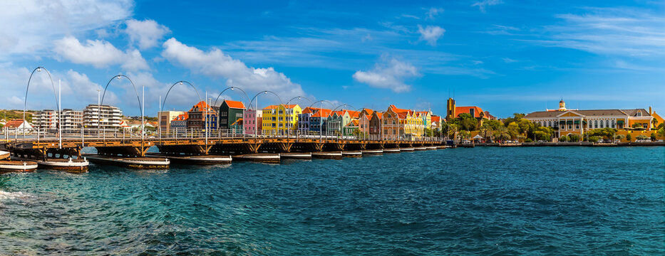 A panorama view across the Queen Emma Bridge over Saint Anna Bay towards the Punda District in Willemstad, Curacao on a bright morning
