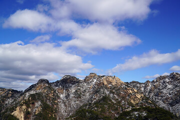 Fototapeta premium Remains of Mt. Bukhan's Amneung, sunny weather, and clouds