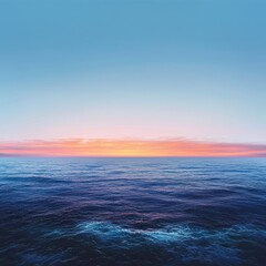 Naklejka premium Serene Ocean Sunset with Soft Orange and Pink Hues Reflecting on Calm Blue Water and Clear Sky