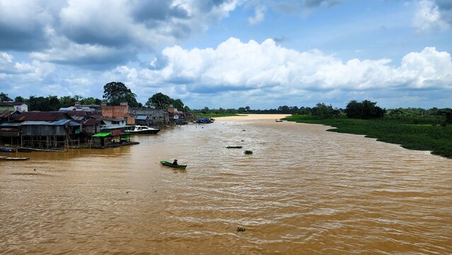 A river with brown water, polluted by environmentally damaging mining activities.