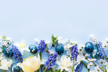 Easter flat lay. Stylish easter eggs, daffodils, tulip and cherry flowers on blue background. Easter celebration, season greetings mockup. Spring modern floral banner © sonyachny