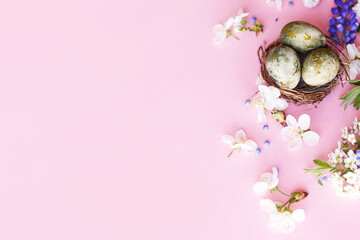Easter flat lay. Stylish easter eggs in nest and cherry flowers on pink background. Easter celebration, season greetings mockup. Spring modern floral banner © sonyachny