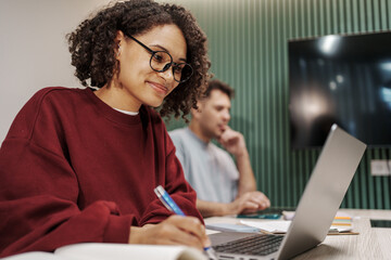 Woman Studying With Pen And Glasses. Young Lady Engaged In Study With Laptop And Attentive...